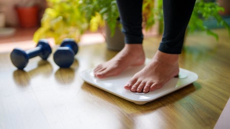 A close-up view of a woman standing on a weighing scale