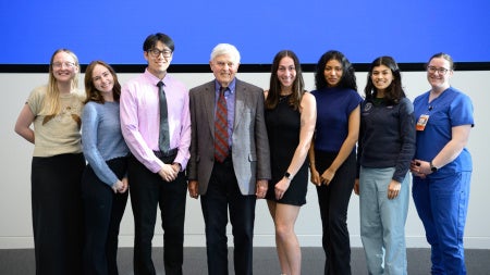 Seven students posing with Dr. Gehlbach against a Blue background 