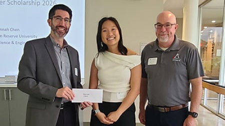 Hannah Chen accepts award with two men standing on either side of her