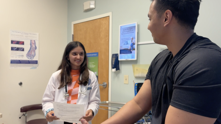 an medical student volunteer helping a patient at Horizons Community Clinic