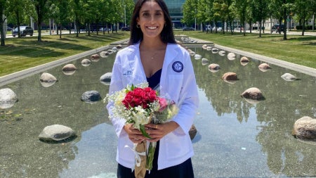 Riddhi Patel posing with flowers in front of the Cleveland Clinic