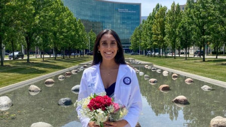 Riddhi Patel posing with flowers in front of the Cleveland Clinic