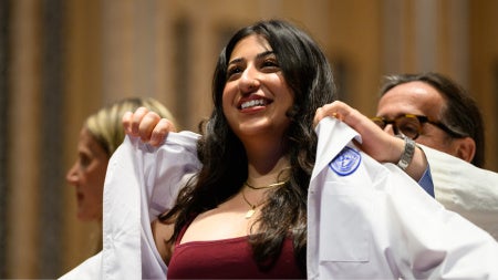 student having her white coat put on her