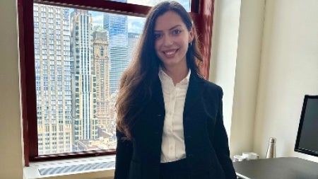 Anna Styer standing at desk in front of window in NYC
