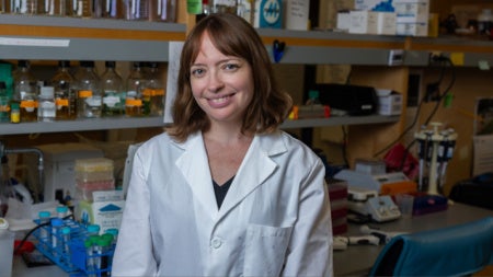 Leah Gates wearing a white coat in a lab setting