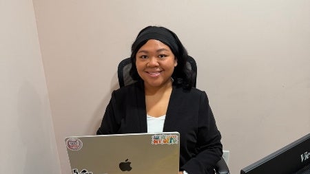 Sydney Jones sitting behind a desk with a laptop