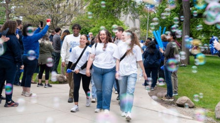 Happy students walk through bubbles at CWRU's annual Clap-Out event. 