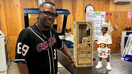 Photo of Mike Crawford in Sears think[box] posing with a custom-made 3D-printed figure and laser-engraved box