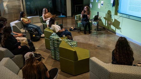 Students sit in modular seating in a classroom at CWRU looking at a document projected on a screen