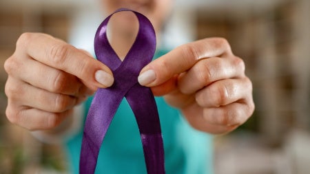 Woman holding purple ribbon 