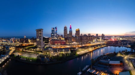 Panoramic view of the Cleveland skyline at dusk with the buildings lit up