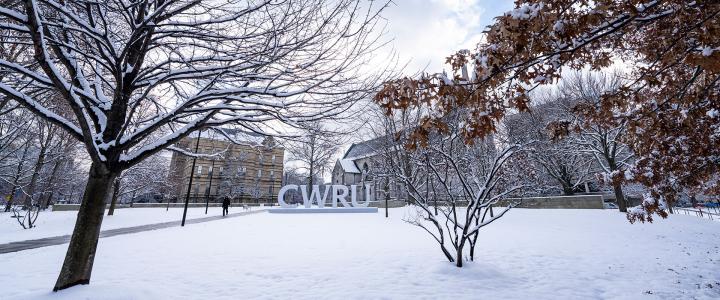 Photo of the CWRU letters on campus surrounded by snow