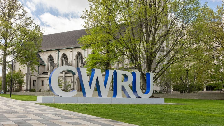 A campus setting with large block letters that read CWRU.