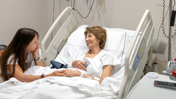 Photo of ICU patient and family member by her hospital bed.