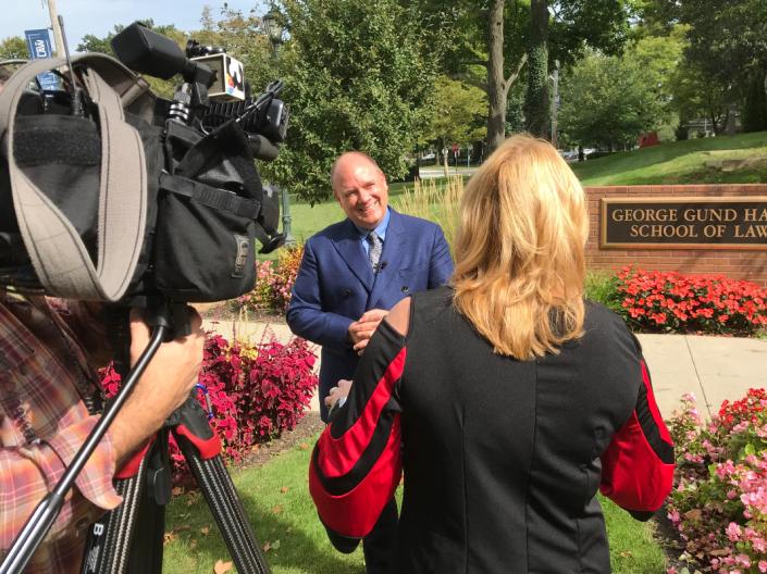 A faculty member being interviewed by the media outside of the Law School building.