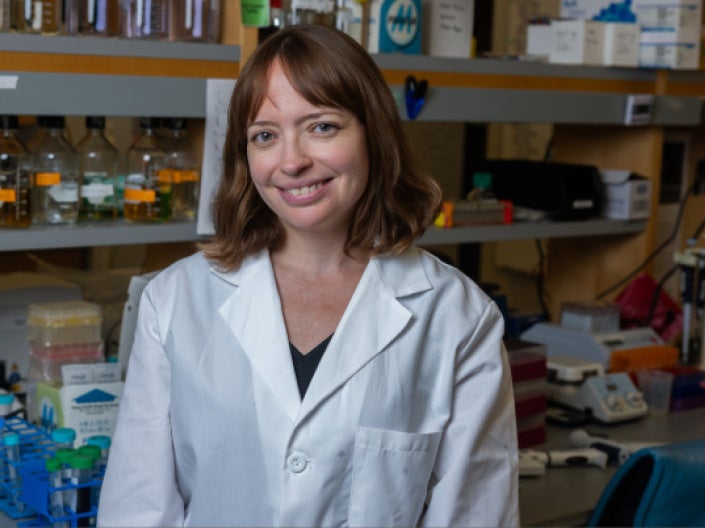 Leah Gates wearing a white coat in a lab setting