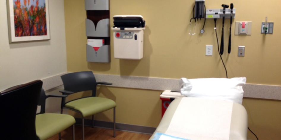 The exam room has two chairs and then a medical bed for the patient.