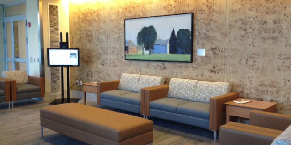 The waiting room has a monitor and couches for patients to sit