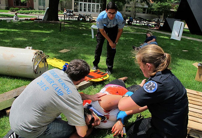 Picture of a student working on a hurt patient in a demonstration.