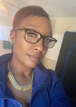 Selfie of black woman wearing glasses and blue shirt