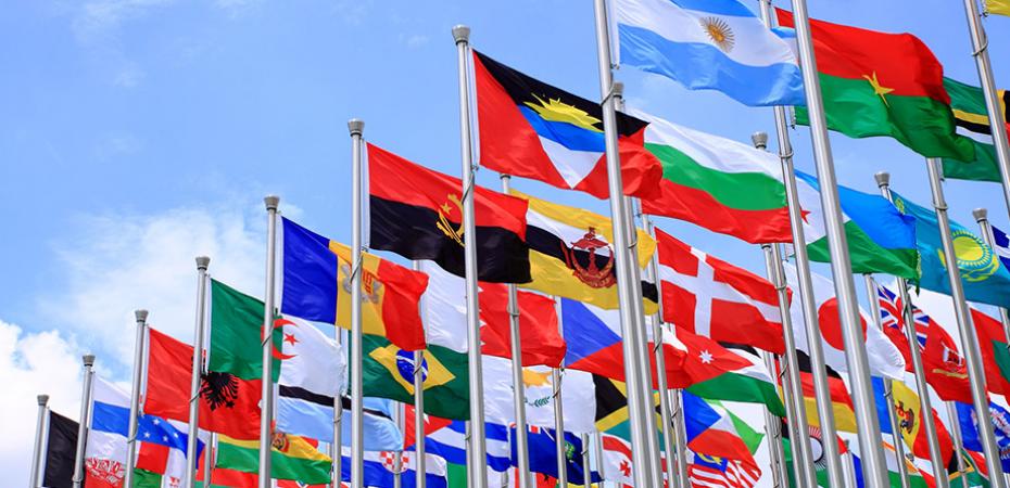 Collection of flags from all over the world blowing in the breeze.