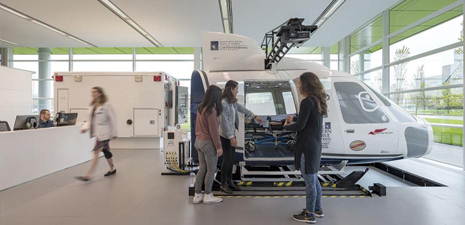 Students looking at the medical helicopter flight simulator.