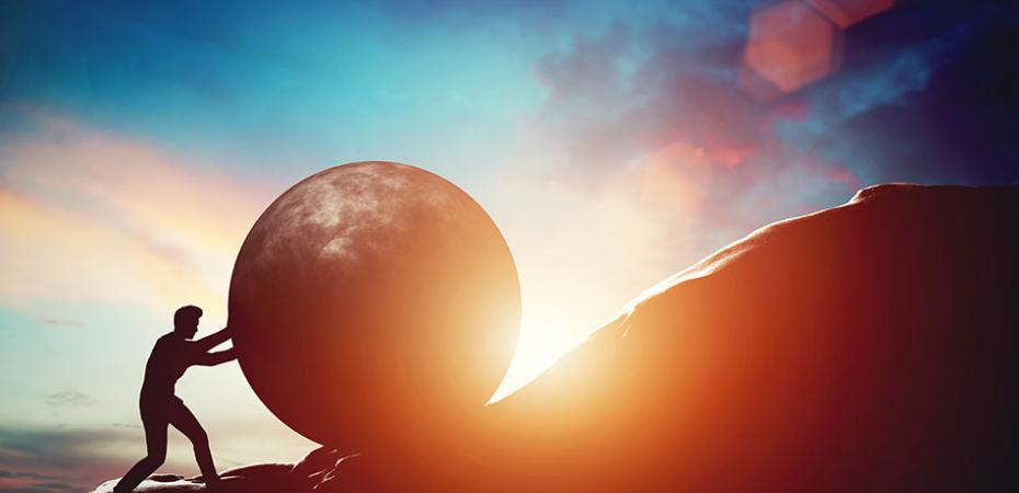 Artists drawing of a man pushing a large sphere up a hill.