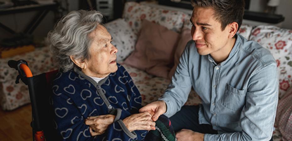 An elderly woman and young man interact