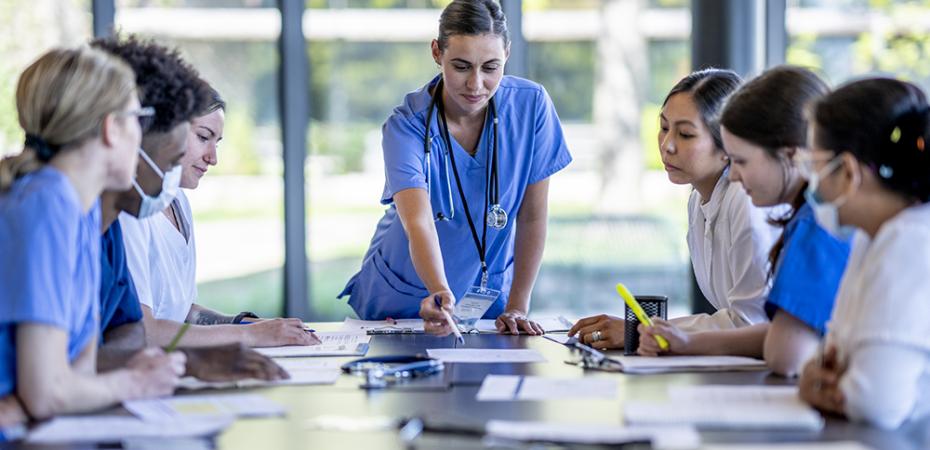 A nurse at center leads a group discussion at a table