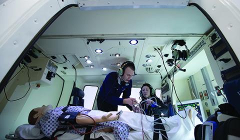 Picture of two students working on a dummy patient during a flight simulation exercise.