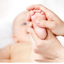 Stock photo of a person holding a babys foot to the camera.