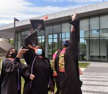 Graduates throwing their mortar boards in the air in Spring 2021.