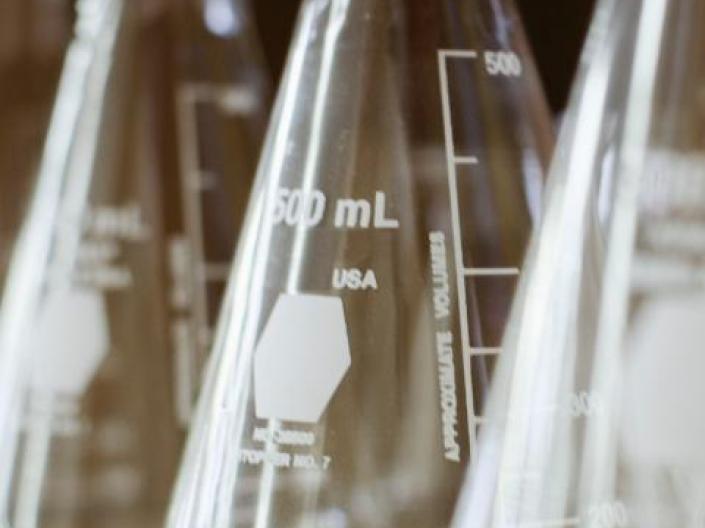 Photo of three lab beakers lined up on a shelf.