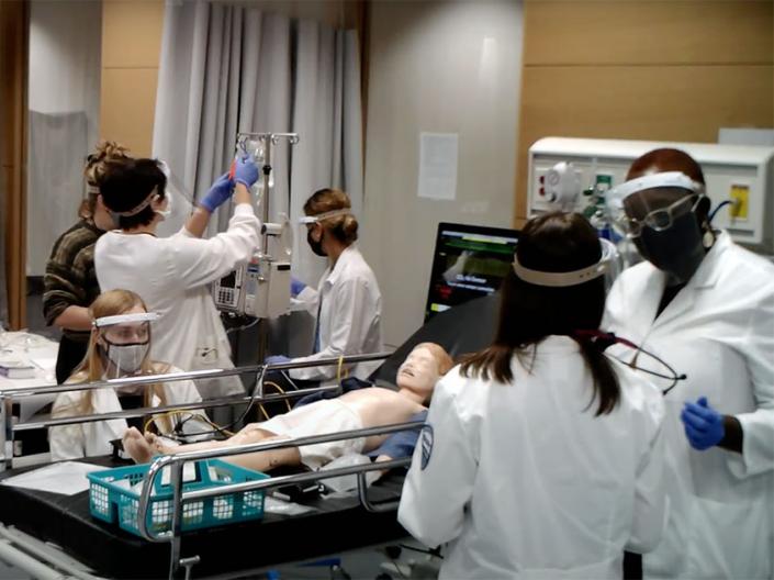 Nursing students wearing PPE work in a clinical lab class in fall 2020.
