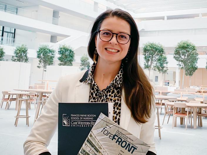 Smiling female holding Frances Payne Bolton School of Nursing Magazines