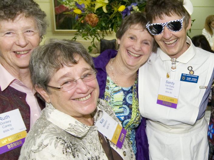 4 women celebrating during homecoming/reunion in the past