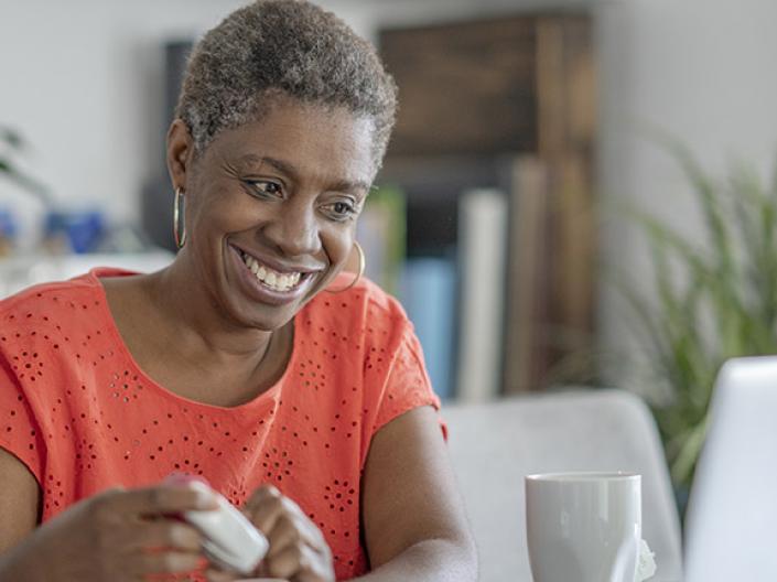 Woman reviewing medication and looking at a computer.
