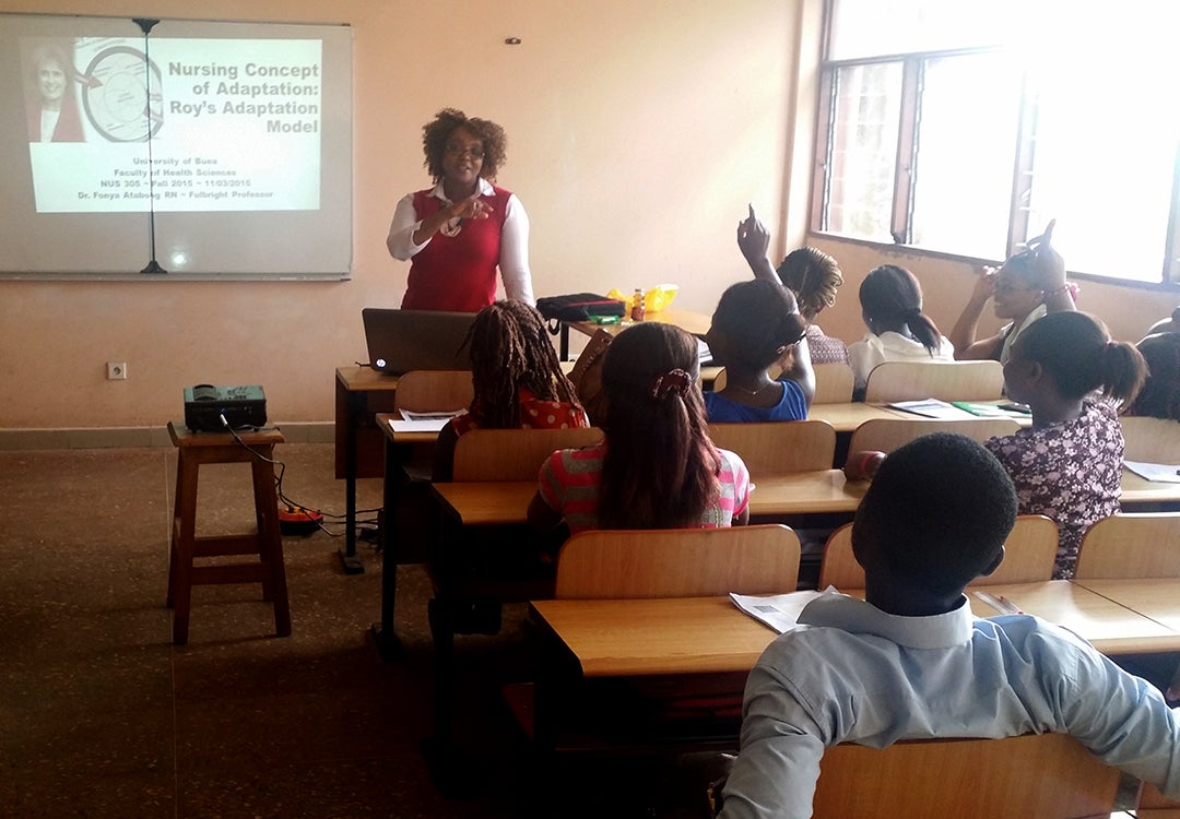 Fonya Atabong teaching in a classroom full of students
