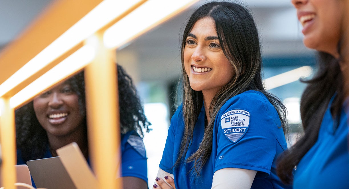 CWRU female nursing student smiling and sitting with other students.
