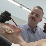 Tom Baum applies special effects to a mannequin in the simulation lab