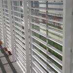 The windows of the HEC with green grass on the other side, sunlight coming through