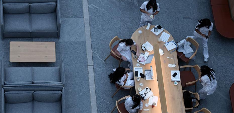 Nursing students gathering and studying at a table.