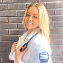 Blonde-hair student in CWRU white nursing scrubs