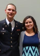 A man in military uniform at left with a woman in blue dress at right