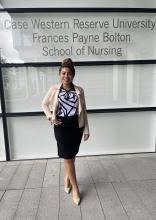 Noel Pacheco, a woman wearing a skirt and blazer, outside the HEC and CWRU School of Nursing building