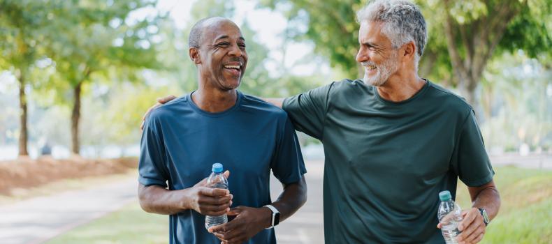 Two older men walking outside, laughing, living healthy