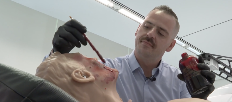 Tom Baum applies special effects to a mannequin in the simulation lab