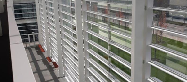 The windows of the HEC with green grass on the other side, sunlight coming through