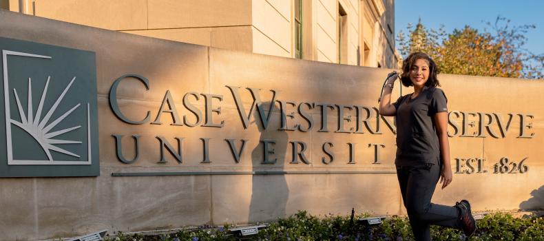 Noel Pacheco, a woman standing at right near a Case Western Reserve university sign