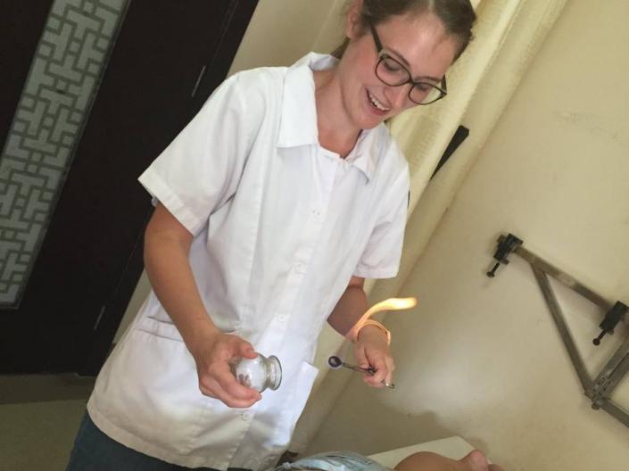 Emily Robson practicing the art of Cupping on a patient.